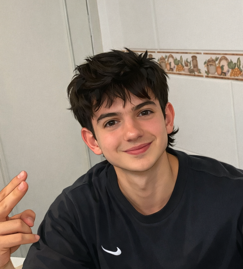 Chico de pelo negro con camiseta negra sonriendo y haciendo un gesto de dos dedos, sentada frente a una pared. Director de marketing de Softly