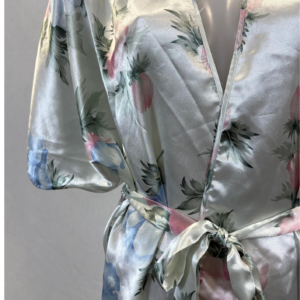 Bata satinada de seda con estampado floral en tonos suaves y cinturón anudado en la cintura.